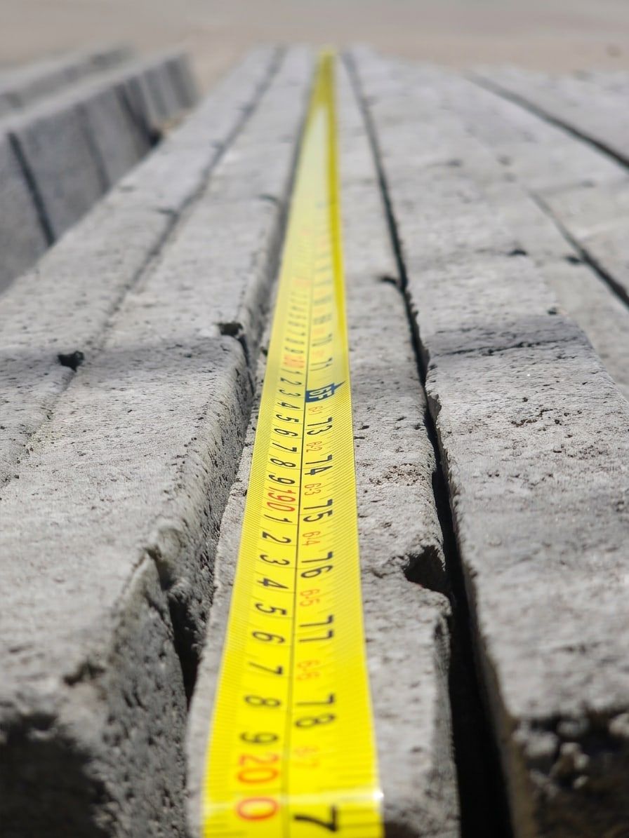 Cinta métrica sobre placas de concreto apiladas, durante el control de medidas