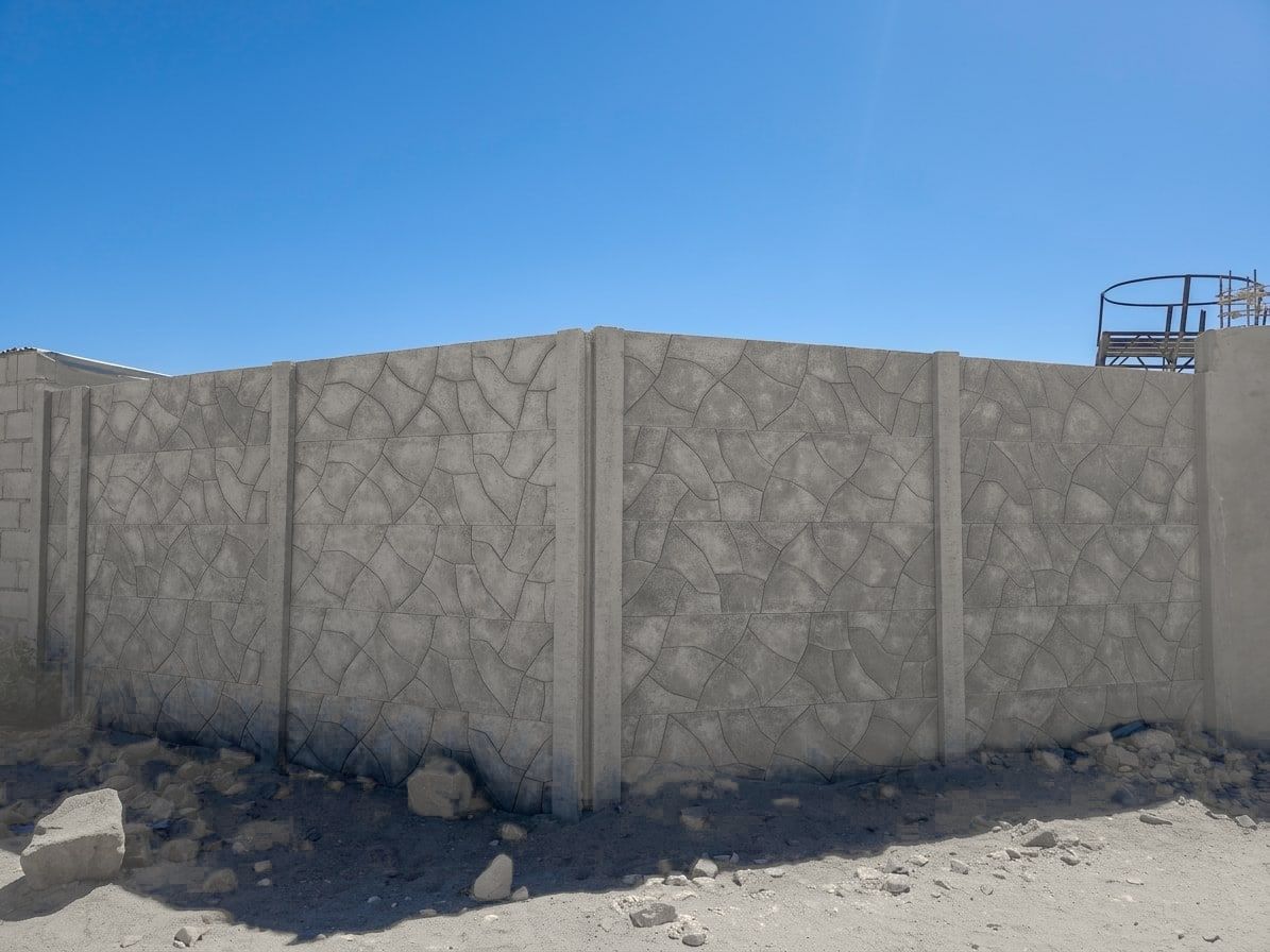 Esquina de un cerco premium con diseño piedra laja, terminado sobre terreno de desierto